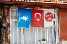 Turkish flag and election flags of Justice and Development Party, Nationalist Movement Party on the window of village house Isparta, Türkiye, 2023
