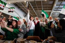 Women wave ‘revolutionary’ Syrian flags in a restaurant in Damascus as they celebrate the fall of the Assad regime last month. Photograph: Omar Sanadiki/AP