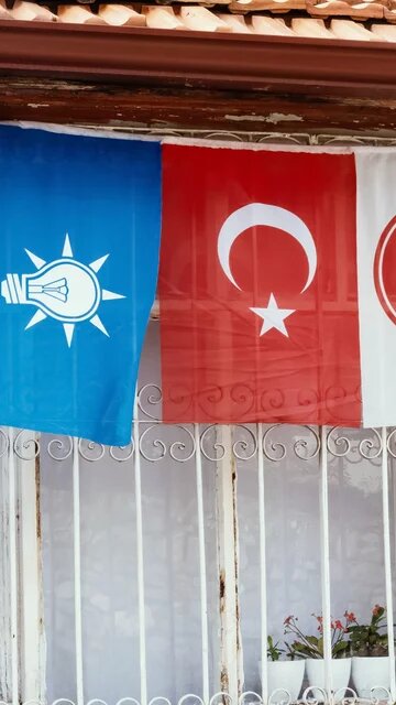 Turkish flag and election flags of Justice and Development Party, Nationalist Movement Party on the window of village house Isparta, Türkiye, 2023