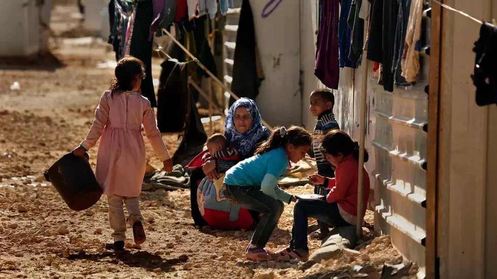 A woman sits with children at Jordan’s Zaatari refugee camp, back in 2016