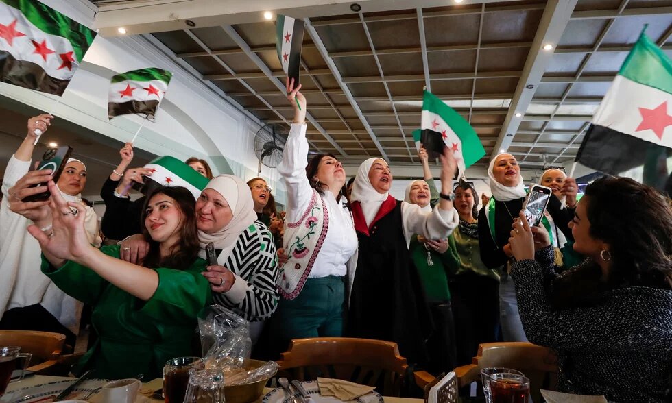Women wave ‘revolutionary’ Syrian flags in a restaurant in Damascus as they celebrate the fall of the Assad regime last month. Photograph: Omar Sanadiki/AP